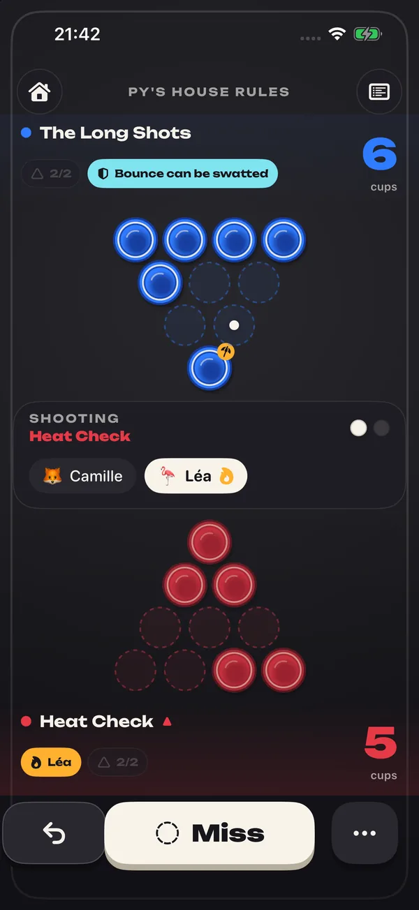 Game screen: two racks of cups seen from above, blue at the top and red at the bottom, the shooting team and the big Miss button.